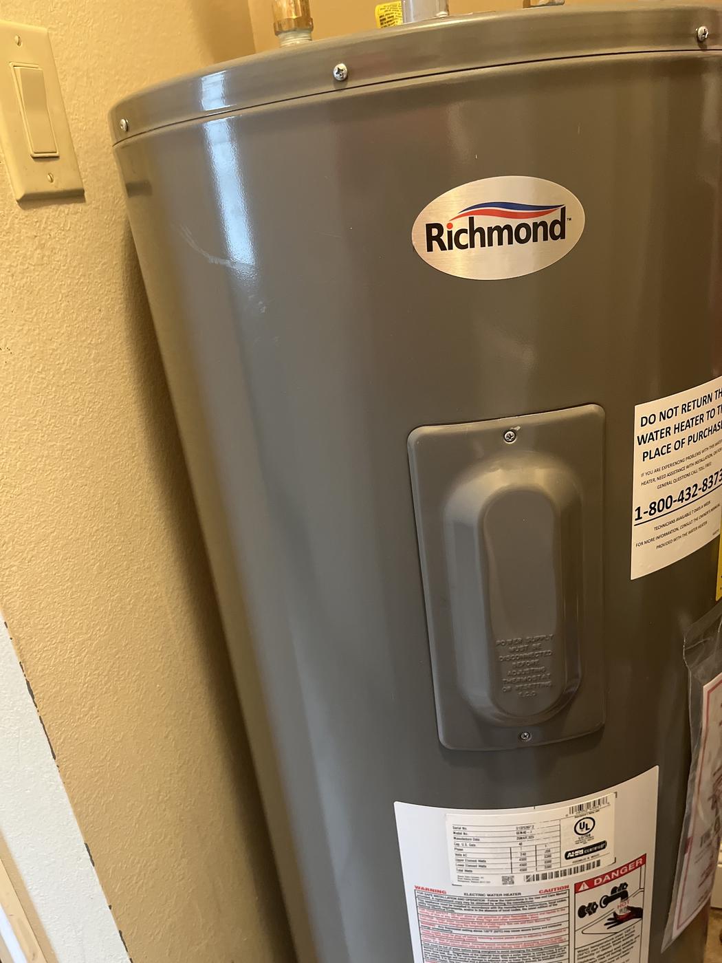 An electric water heater in place. Its own label reads electric.