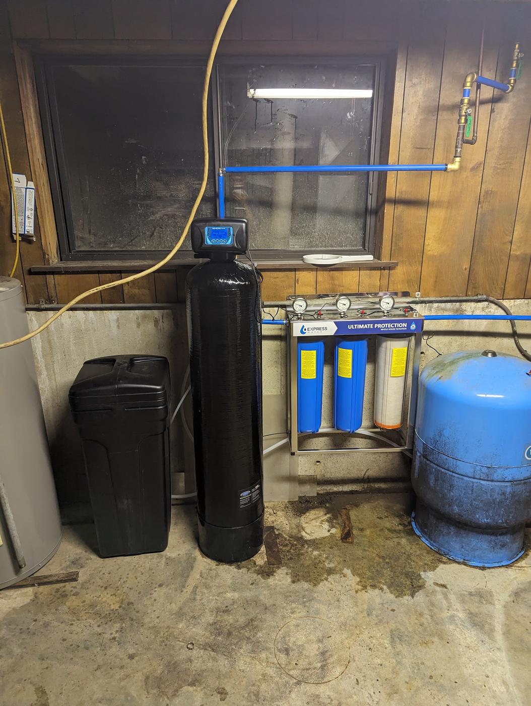 A water softener, filter housing and pressure tank, piped in.